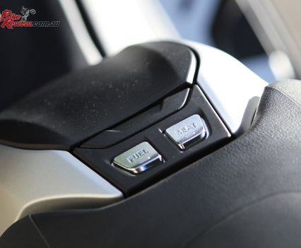 A console in front of the seat features a seat and fuel button, with the fuel cap hidden in the panel in front