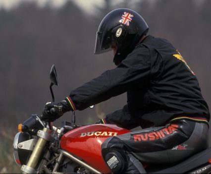 Knees tucked into the tank, Cathcart dwarfs the bike.